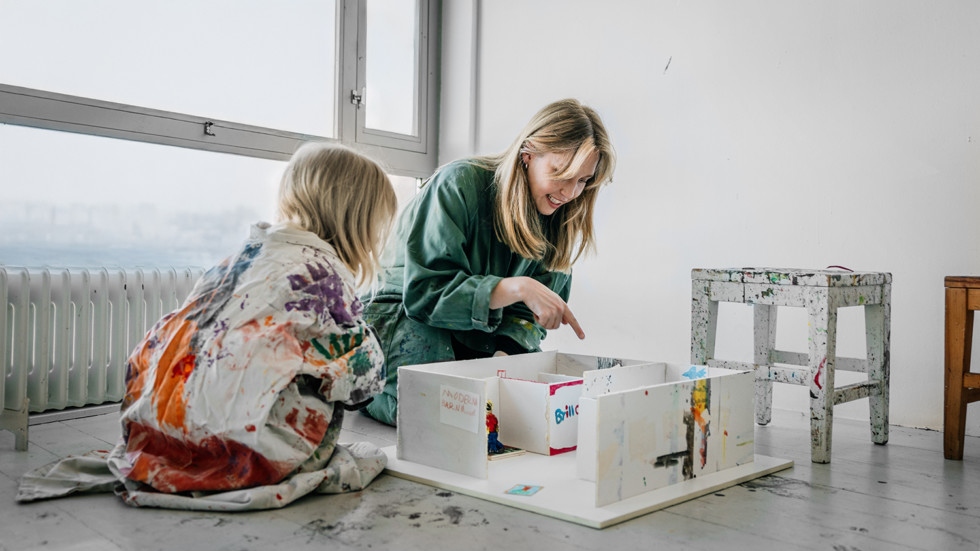 An adult and a child creating a miniature museum in the Workshop