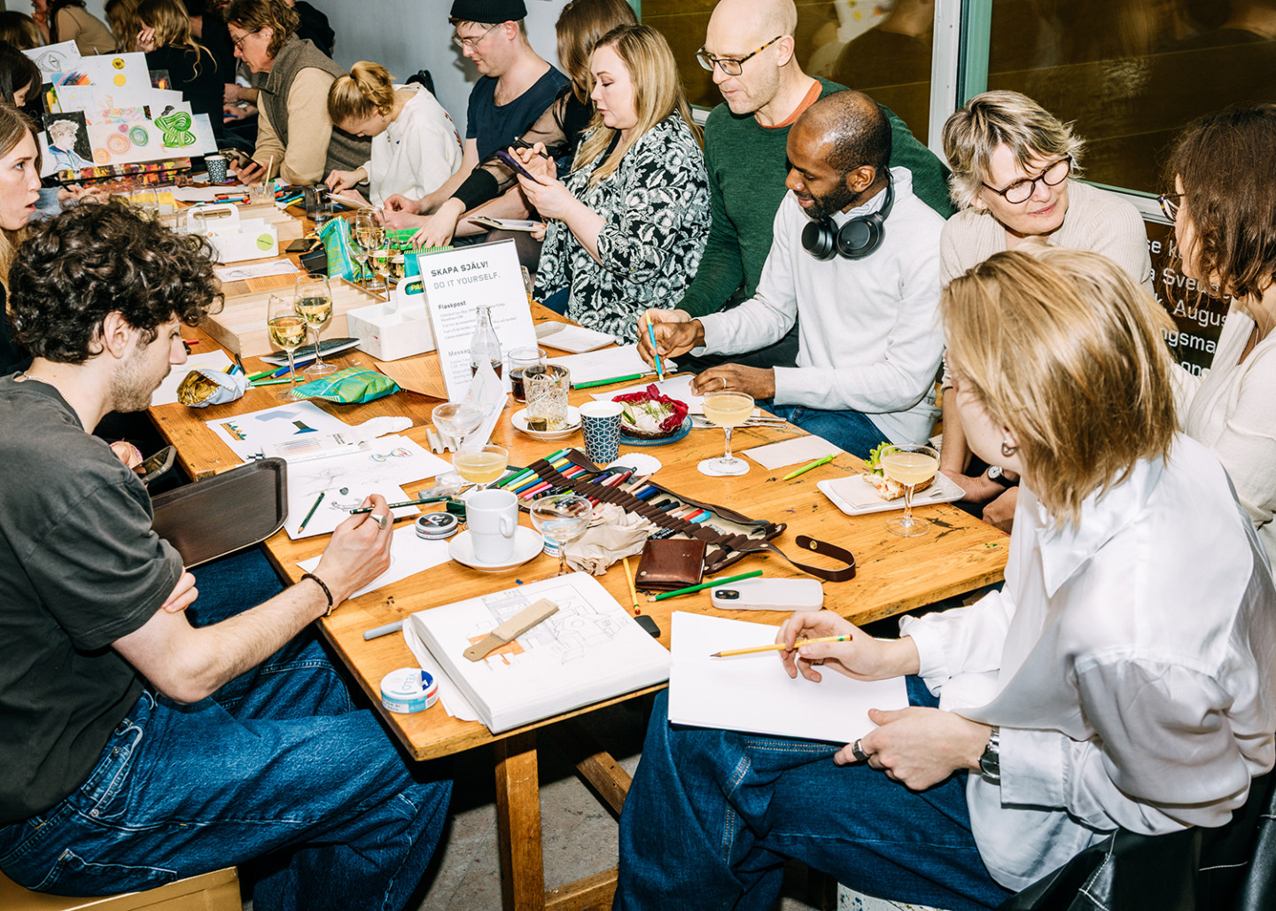 People are drawing together at a long table in the museum