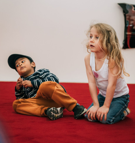 Två barn leker på golvet
